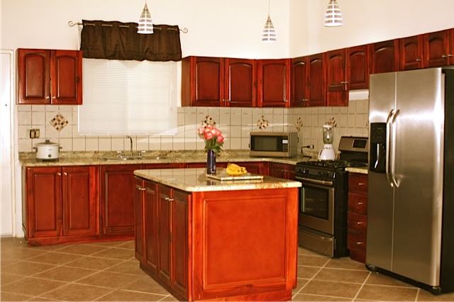 Kitchen with teak cabinets, granite countertops and stainless steel appliances